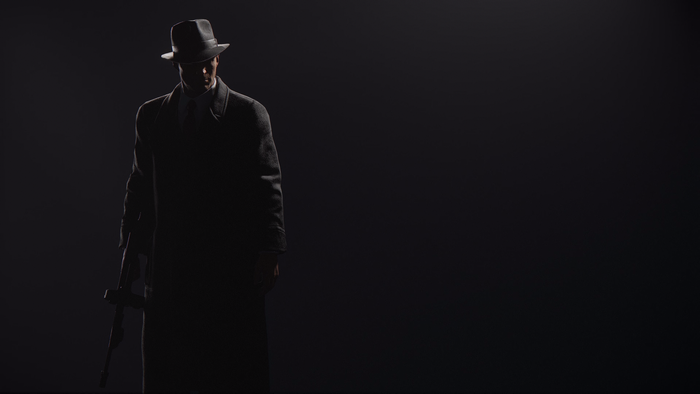 Man in fedora and trench coat holding a gun in Mafia: Definitive Edition