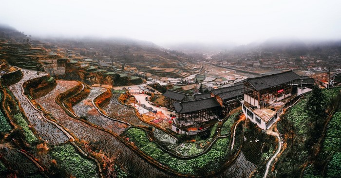 Terraced rice fields and traditional Chinese village in fog