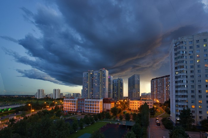 Cityscape at dusk with dramatic storm clouds and apartment buildings