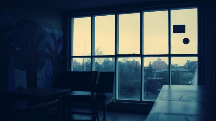 Interior with large window overlooking rainy town