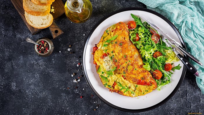 Omelette with salad, bread, and olive oil