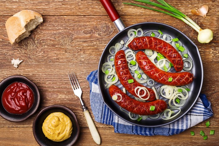 Sausages with onions, bread, mustard, and ketchup