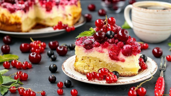 Slice of berry cake with fresh berries and coffee