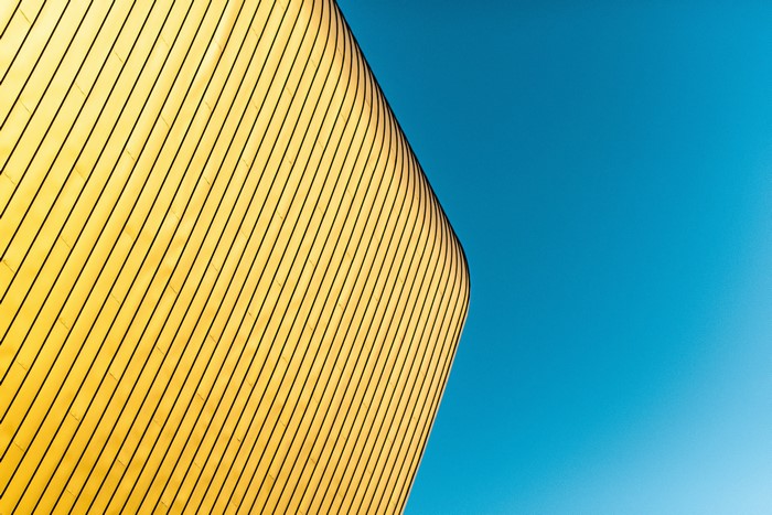 Minimalist yellow building facade against a blue sky
