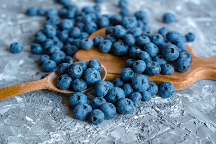 Blueberries on wooden spoons and cutting board