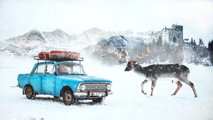 Blue Moskvich car with deer in snowy landscape with castle