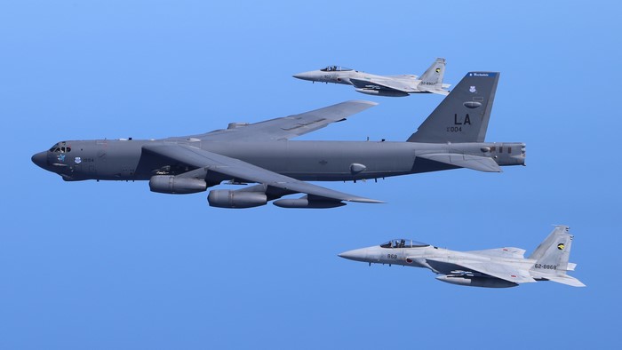 Boeing B-52 Stratofortress and McDonnell Douglas F-15 Eagles in flight
