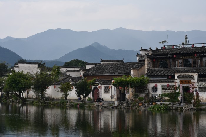 Traditional Chinese village by the water with mountains