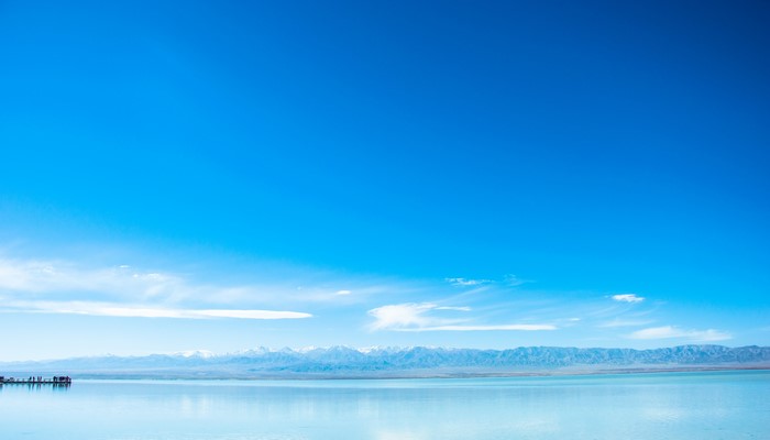 Vast blue sky over a calm lake and distant mountains
