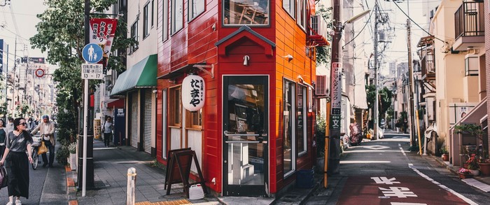 Street corner with red building and people in Asia