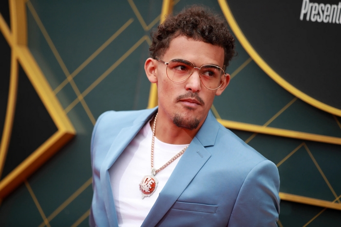 Trae Young in a light blue suit with a diamond necklace