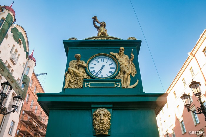 Green clock tower with statues in Russia