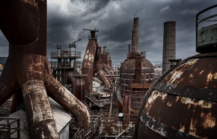 Abandoned industrial complex with rusty metal structures and smokestacks