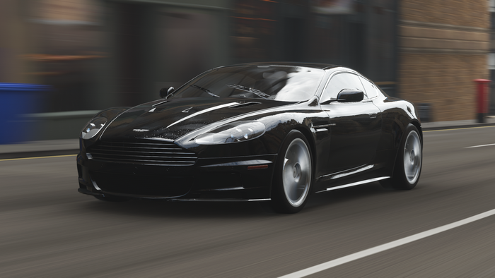 Black Aston Martin DBS driving on a street