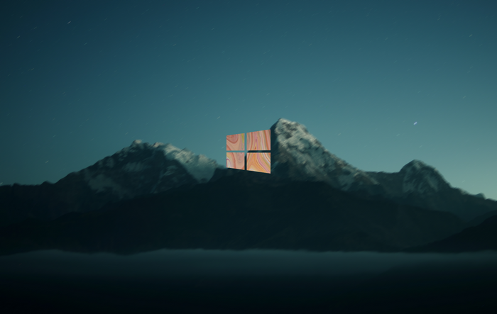 Windows 10 logo over mountains at night