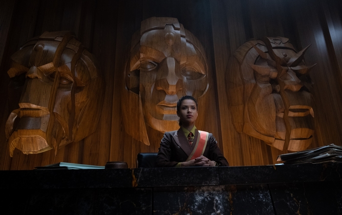 Ravonna Renslayer in front of carved heads