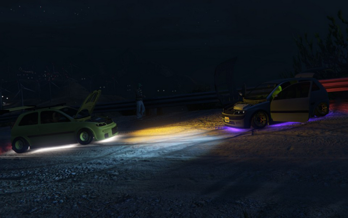 Two cars with hoods up at night