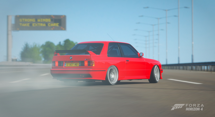 Red BMW M3 E30 drifting on highway in Forza Horizon 4
