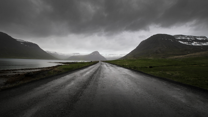 Road through a Fjord in Iceland with Mountains and Clouds
