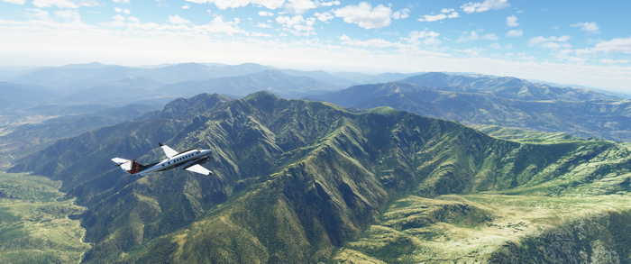 Airplane flying over mountains in flight simulator