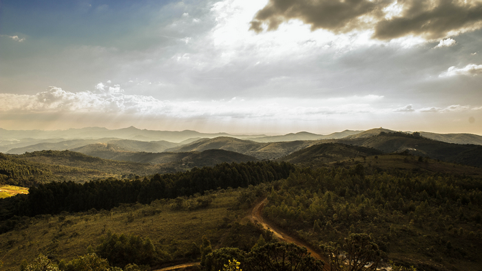 Rolling Hills and Mountains Under a Cloudy Sky