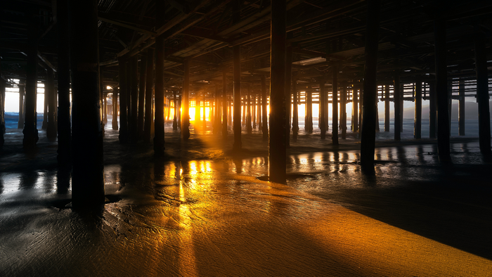 Sunrise under a pier in California