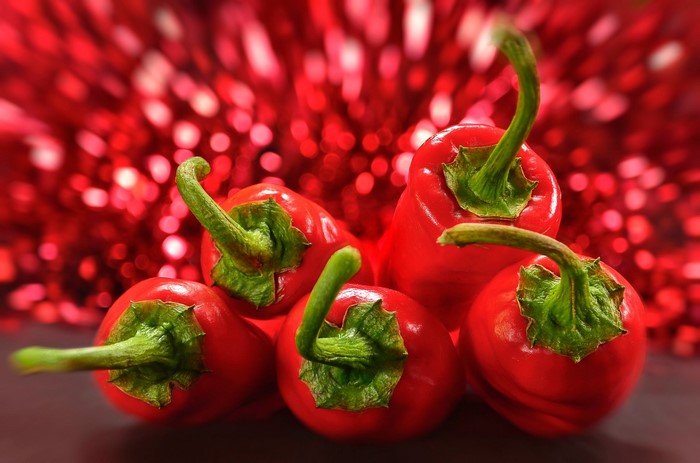 Red chili peppers with green stems on a bokeh background