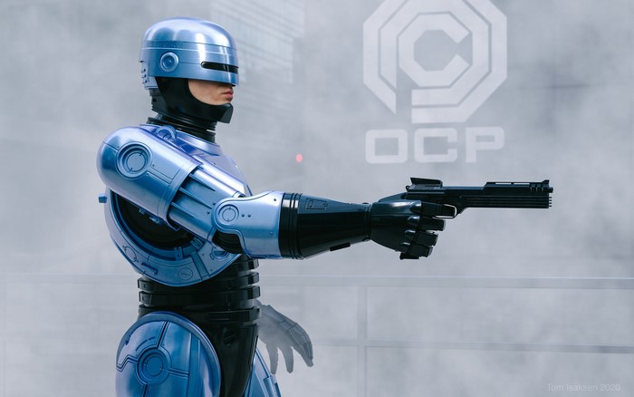 RoboCop holding a gun with OCP logo in background