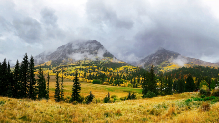 Mountain landscape with autumn trees and clouds