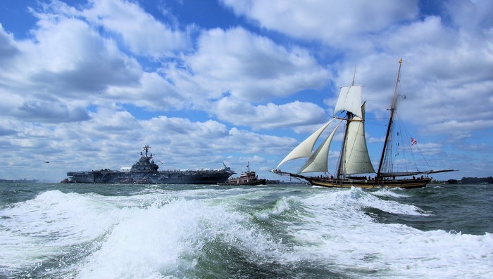 Sailing ship and aircraft carrier on the sea