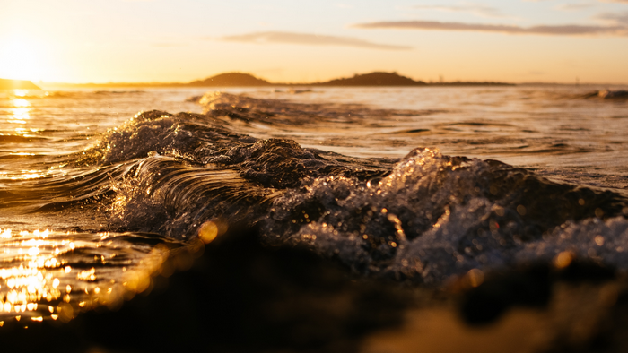 Waves crashing on the shore at sunset