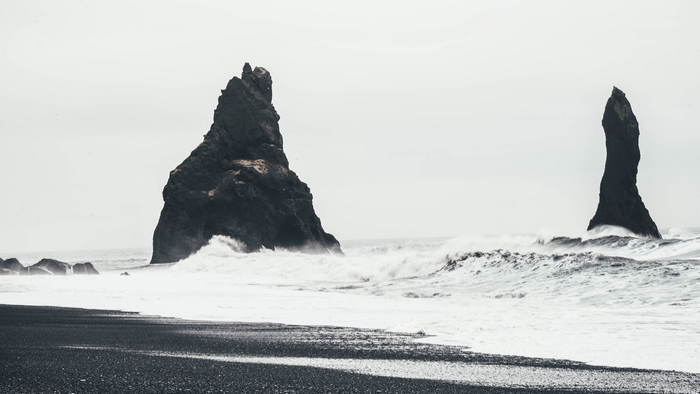 Black sand beach with rock formations and waves in Iceland