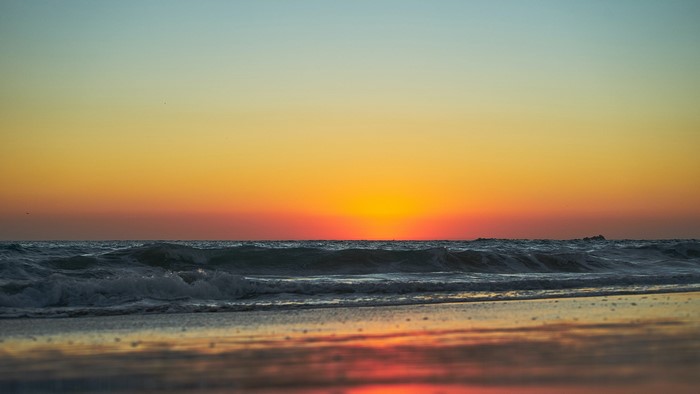 Sunset over the ocean with waves