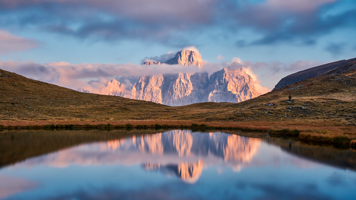 Mountain reflection in a lake at sunrise, Dolomites, Italy