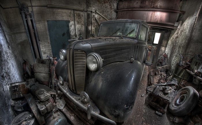 Abandoned vintage car in a dusty garage