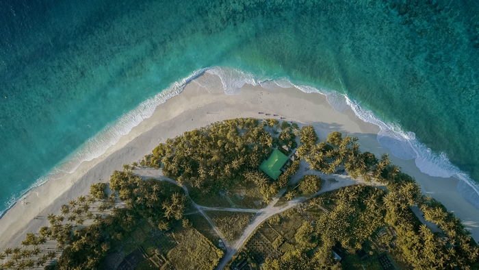 Aerial view of a tropical island with a beach and turquoise water