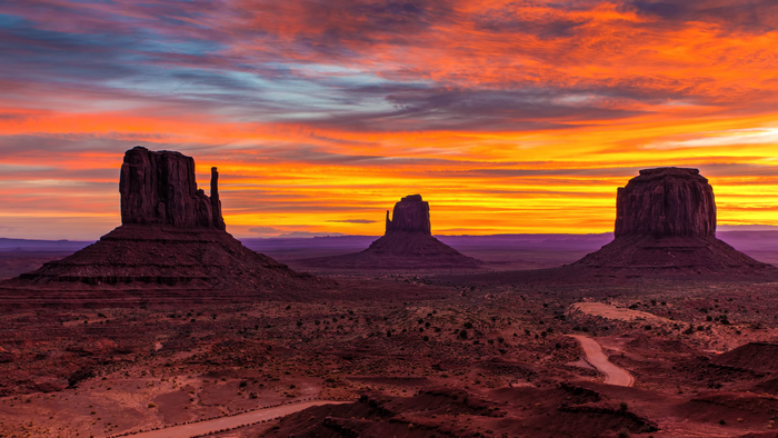 Monument Valley landscape at sunset with mesas and road