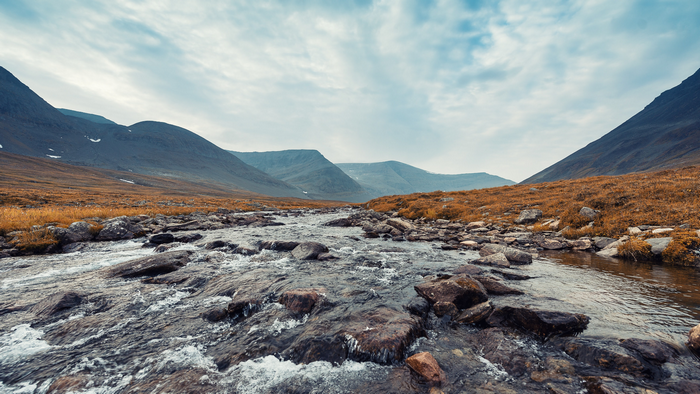 Mountain landscape with a river and dry grass