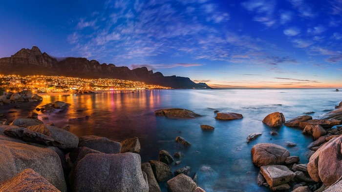 Cape Town coastline with mountains and city lights at dusk