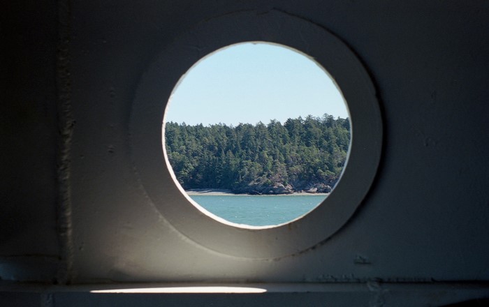 View of forested island through a porthole
