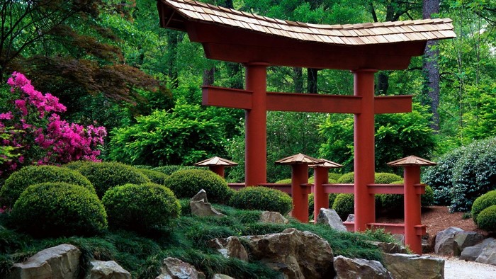 Japanese garden with red torii gate and pink azaleas