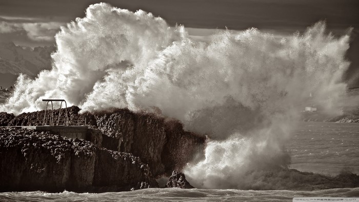 Sepia waves crashing on rocky shore with diving board