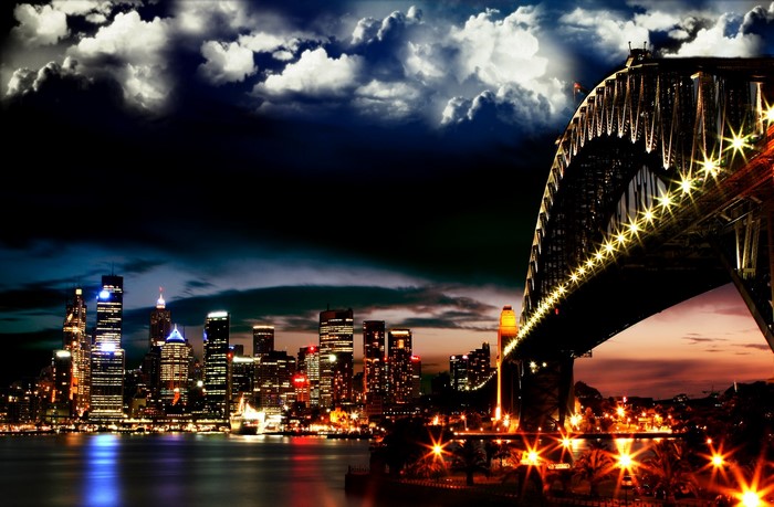 Night cityscape with illuminated bridge and skyscrapers