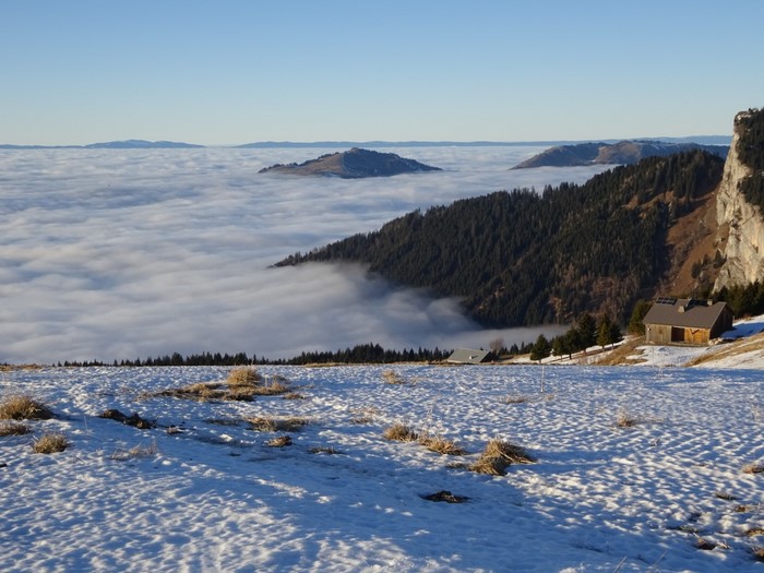 Mountain landscape with clouds and a cabin