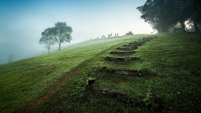 Misty mountain landscape with stairs and people