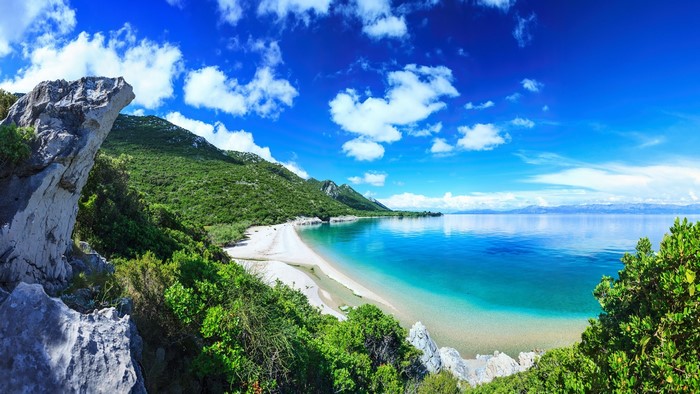 Scenic beach in Croatia with turquoise water and green hills