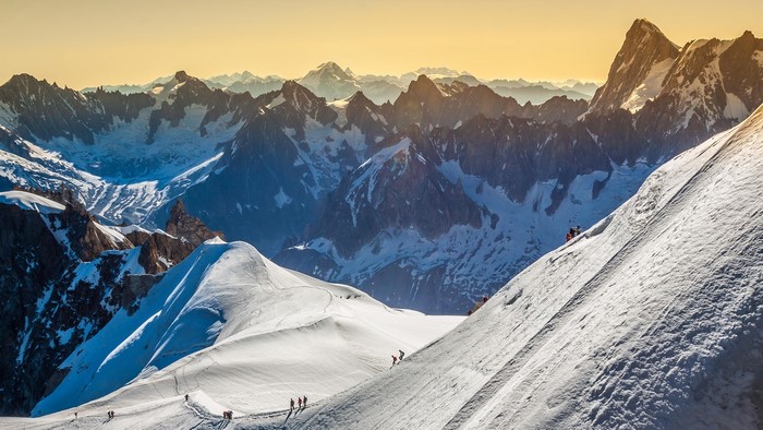 People climbing a snowy mountain in the Alps