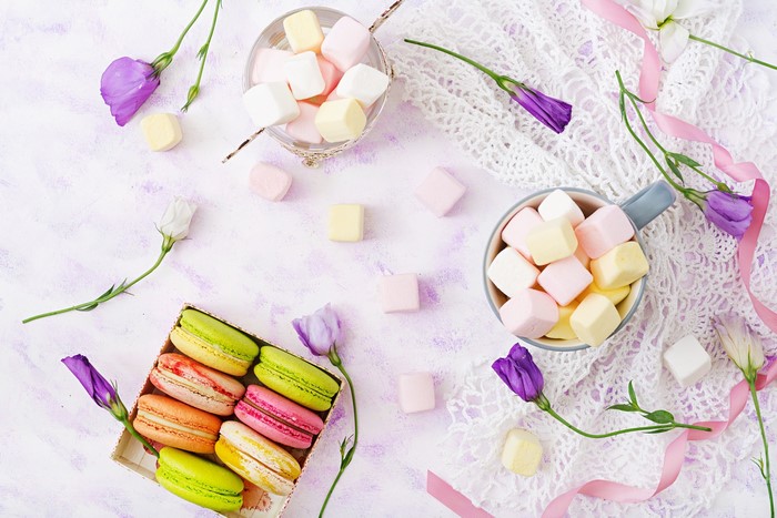 Colorful marshmallows and macarons with flowers