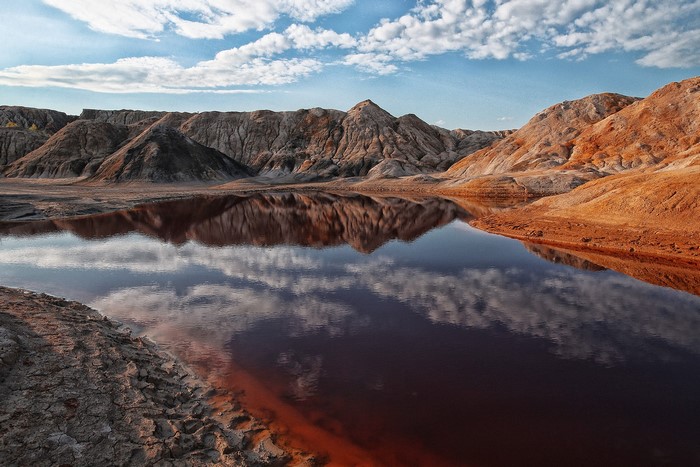 Barren landscape with red water and mountains