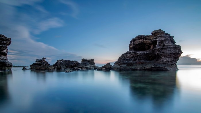 Long exposure of rocks in the ocean at dusk
